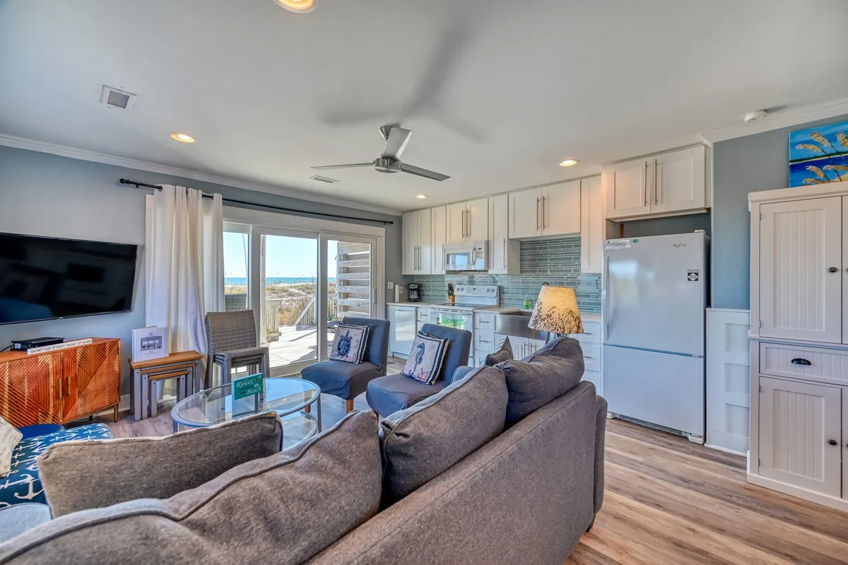 A spacious living area with large windows offering views of the outside, a comfortable sofa perfect for gathering after a day of exploring, and a kitchen area nearby. The natural light and inviting furnishings suggest a seamless transition between indoor relaxation and outdoor adventure.